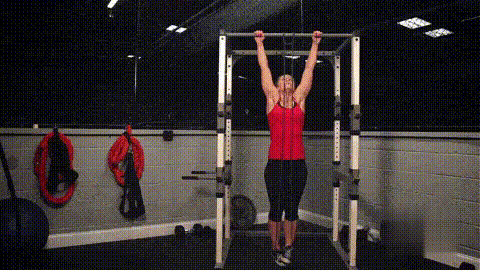 Coach using a band for an assisted pull-up.